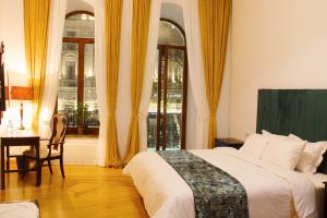 um quarto com uma cama, uma secretária e uma janela em Octava Boutique Hotel em Tbilisi