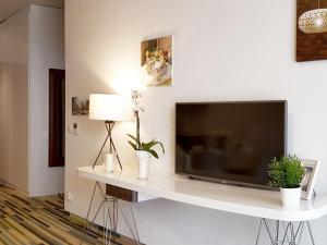 een woonkamer met een televisie op een witte plank bij VacationClub - Baltic Park Molo Apartment C109 in Świnoujście