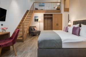 ein Schlafzimmer mit einem großen Bett und einer Treppe in der Unterkunft Hotel Obermaier in München