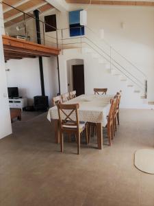 a dining room with a table and chairs and stairs at Casa S'Olibassa in La Mola