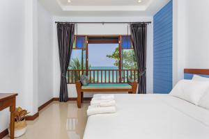 a bedroom with a bed and a window with a chair at The Boutique Khanom in Khanom