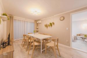 a dining room with a white table and chairs at SeeU House Hongdae in Seoul