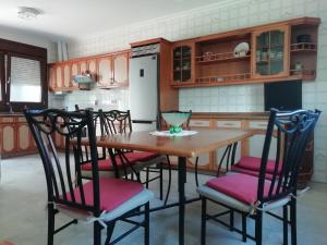 a kitchen with a wooden table and four chairs at Casa Airiños do monte in Cangas de Morrazo