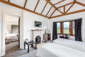 a bedroom with two beds and a fireplace at Grey Harlings Hotel in Montrose