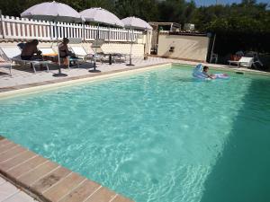 a child is playing in a swimming pool at Agriturismo Terre D'Ulivi in Moscufo