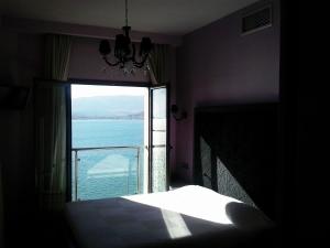 sypialnia z oknem z widokiem na ocean w obiekcie Hotel Kipseli w mieście Wolos