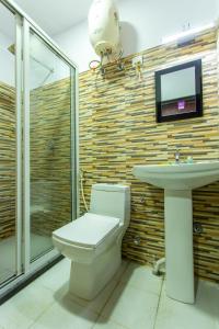 een badkamer met een toilet, een wastafel en een tv bij HOTEL PARK VICTORIA in Calcutta