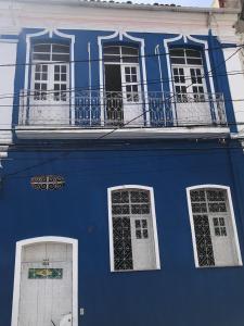 Edificio azul con 3 ventanas y balcón en Brazil Inn Hostel, en Salvador