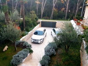 two white cars parked in a parking lot at Apartmani Val in Pula
