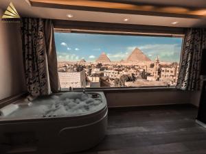 uma casa de banho com vista para as pirâmides a partir de uma janela em Pyramid Edge Hotel no Cairo