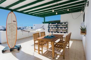 una sala da pranzo con tavolo e tavola da surf di La Siesta Azul a Playa Blanca