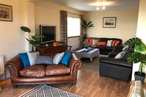 Телевизор и/или развлекательный центр в Whitehead holiday cottage