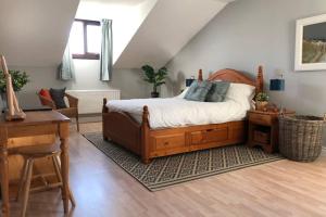 - une chambre avec un lit en bois et un bureau dans l'établissement Whitehead holiday cottage, à Whitehead