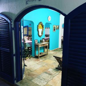 an archway leading into a room with a table and a mirror at Villa Di Verona Charm Hotel in Guarujá