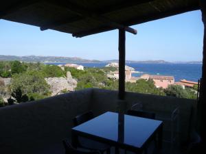 a table on a balcony with a view of the ocean at Cormorani Alti in Baja Sardinia