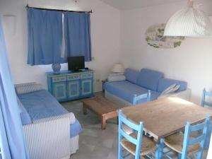 a living room with a blue couch and a table at Cormorani Alti in Baja Sardinia