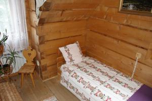 a bedroom with a bed and a wooden wall at Pokoje Gościnne Kościelisko AZ Somatic in Kościelisko
