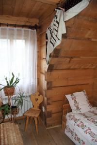 a bedroom in a log cabin with a bed and a window at Pokoje Gościnne Kościelisko AZ Somatic in Kościelisko