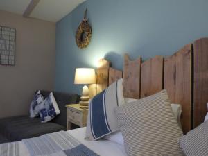 a bedroom with a bed with a wooden headboard and a couch at The Cross Guest House in Mablethorpe
