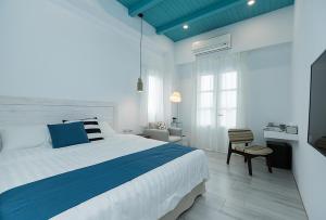 a bedroom with a blue and white bed and a chair at Blue White in Wujie