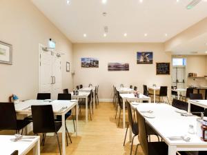 a dining room with white tables and chairs at Lost Guest House Stirling in Stirling
