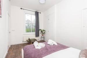 ein weißes Schlafzimmer mit 2 Handtüchern auf dem Bett in der Unterkunft Modern, Romantic Apartment in York - Pass the Keys in York