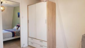 ein Schlafzimmer mit einem weißen Schrank und einem Bett in der Unterkunft Gite D'Elnon-Libre in Saint-Amand-les-Eaux