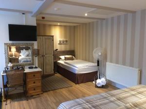 a bedroom with two beds and a desk and a mirror at The Cross Guest House in Mablethorpe