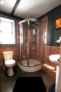 a bathroom with a shower and a toilet and a sink at The Cross Guest House in Mablethorpe