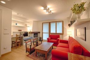 クールマイヨールにあるALTIDO Superb Apartments for 6 with Mountain View and Garden in Courmayeurのリビングルーム(赤いソファ、テーブル付)
