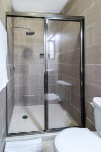 a glass shower in a bathroom with a toilet at PRIME VILLAGE Cozumel in Cozumel