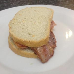 ein Sandwich mit Speck auf einem weißen Teller in der Unterkunft The Cross Guest House in Mablethorpe + 13 Fotos