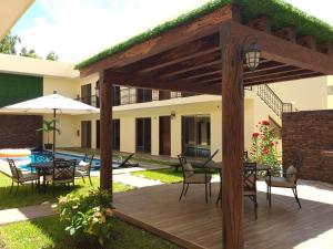 een houten terras met een tafel en stoelen en een parasol bij PRIME VILLAGE Cozumel in Cozumel