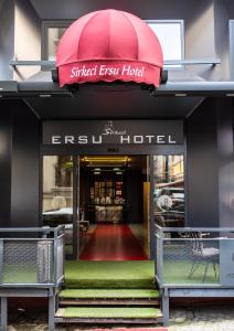 Sirkeci Ersu Hotel & SPA في إسطنبول: مدخل لفندق مخرج الشارع مع مظلة حمراء