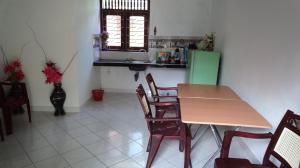 a dining room with a table and chairs and a kitchen at Sea Side Bay House in Weligama