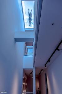 a person walking through a window in a building at Welldone Quality - Crystal pool in Seville