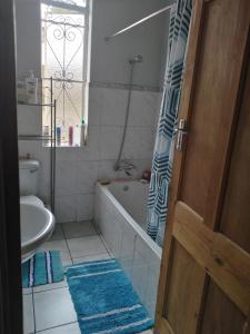 a bathroom with a tub and a toilet and a sink at Rosegarden guest house in Johannesburg