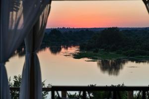 a view of a lake at sunset from a tent at Simbavati Hilltop Lodge in Timbavati Game Reserve