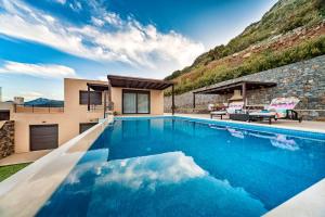 uma piscina em frente a uma casa em villa OLGA - Sea and mountains view Private pool em Elounda