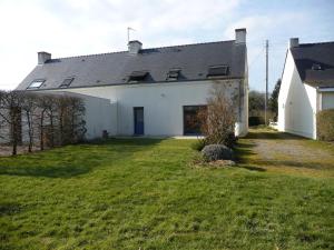 a large white house with a grass yard at Gîte du pré de la dame in Férel