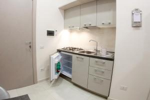 una cucina con lavandino e piano cottura forno superiore di Casa del Sol a Napoli