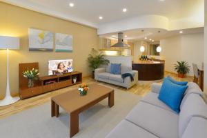 a living room with a couch and a tv at Somerset Al Fateh Bahrain in Manama