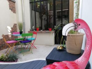 ein rosa Flamingo steht auf einem Tisch auf einer Terrasse in der Unterkunft Le loft d Oscar Hyper centre parking possible in Rouen