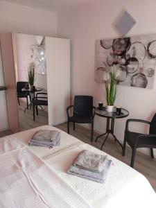 a bedroom with a bed and chairs and a mirror at Rooms Bero in Senj