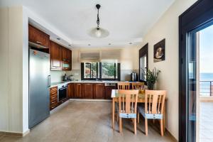 a kitchen with a table with chairs and a refrigerator at villa OLGA - Sea and mountains view Private pool in Elounda