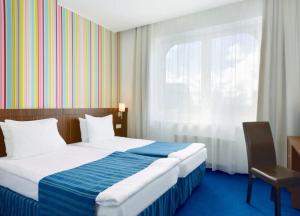 Postel nebo postele na pokoji v ubytování Rija VEF Hotel with FREE Parking