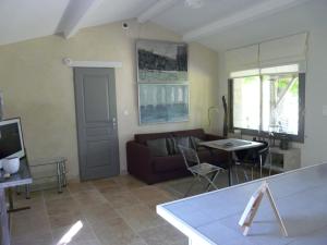a living room with a couch and a table at Les Lebes - La petite maison in Sempesserre