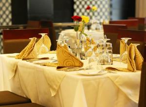 a table with yellow napkins and a vase with a flower on it at Daamat Hotel in Addis Ababa