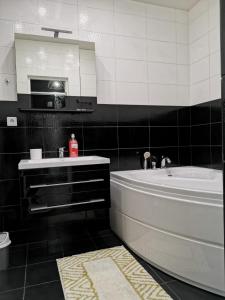 y baño con bañera, lavabo y espejo. en Квартиры на берегу реки - ЖК Европейский en Krasnodar