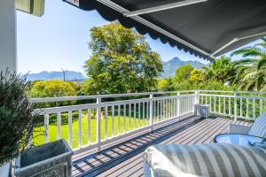 a porch with a white fence and a view of the mountains at No.10 Caledon Street Guest House in George